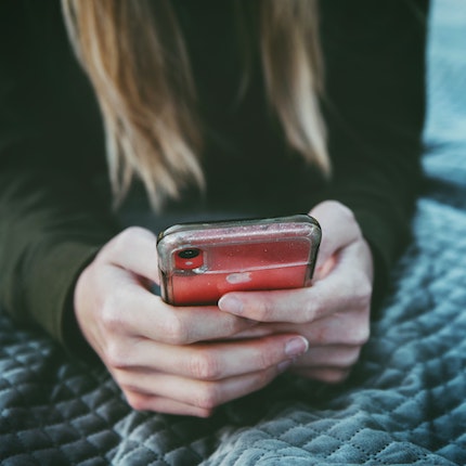 Foto: Frau schaut auf Smartphone